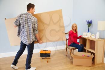 Couple Preparing To Assemble Flat Pack Furniture In Nursery