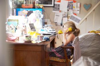 Girl Sitting At Desk In Parents Home Office