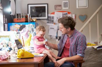 Father With Daughter Running Small Business From Home Office