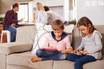 Kids playing with new technology while adults entertain