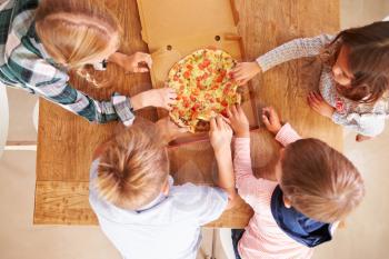 Children sharing a pizza together, overhead view