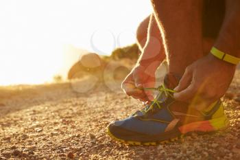 Close up of a man doing up his running shoes