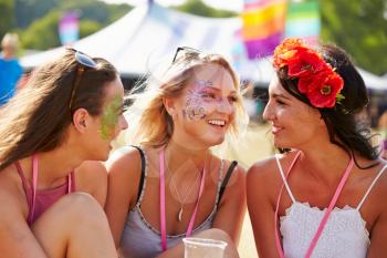 Three girl friends talking at a music festival