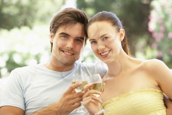 Portrait Of Young Couple Relaxing On Sofa Drinking Wine Together