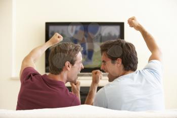 Two Men Watching Widescreen TV At Home