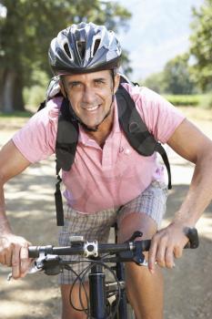 Middle Aged Man Cycling Through Countryside