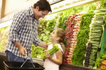 Father and daughter buying vegetables in supermarket