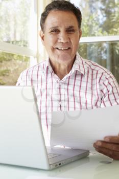 Senior Hispanic Man Working In Home Office