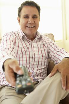 Senior Hispanic Man Using TV Remote Control