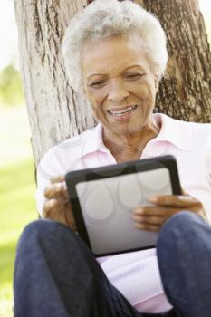 Senior African American Woman In Park Using Tablet Computer