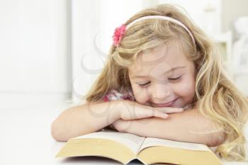 Young Girl Reading Book In Bedroom