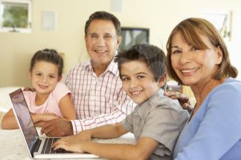 Hispanic Grandparents And Grandchildren Using Computer At Home