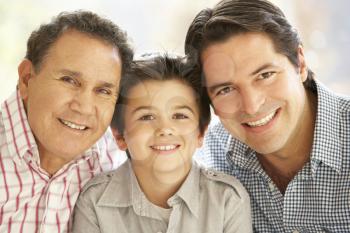 Portrait Of Hispanic Grandfather, Adult Father And Son Relaxing At Home