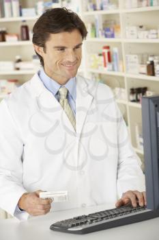 Pharmacist working on computer in pharmacy