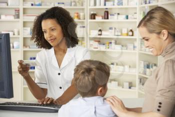 Pharmacist in pharmacy with mother and child