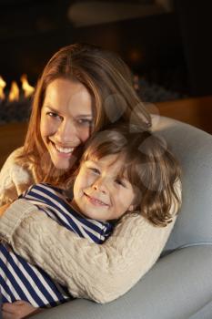 Portrait mother and son sitting in front of fire