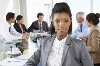 Businesswoman Sitting Around Boardroom Table With Colleagues