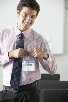 Male Delegate Attaching Name Badge At Conference