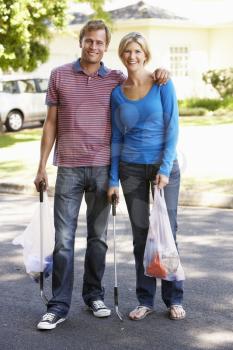 Couple Picking Up Litter In Suburban Street