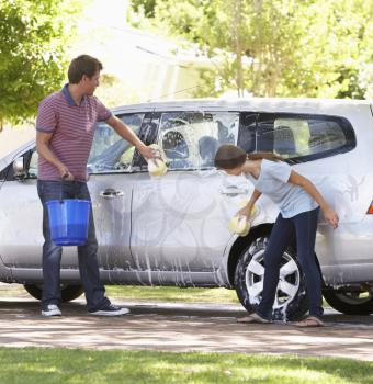 Father And Teenage Daughter Washing Car Together