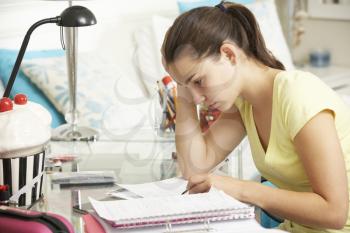 Teenage Girl Studying At Desk In Bedroom
