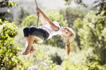 Young Girl Having Fun On Rope Swing