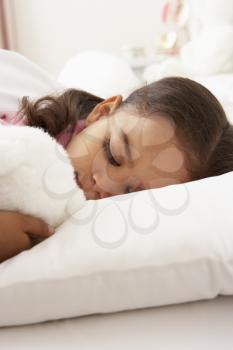 Young Girl Asleep In Bed With Cuddly Toy