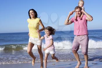 Family Running Along Beach Together