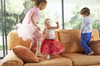 Group Of Children Jumping On Sofa