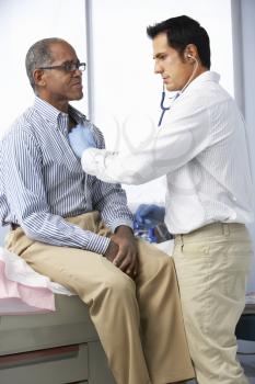 Doctor In Surgery Listening To Male Patient's Chest