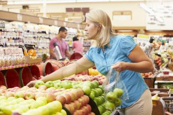 Woman At Fruit Counter In Supermarket