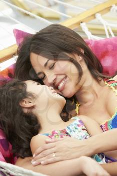 Mother And Daughter Relaxing In Garden Hammock Together