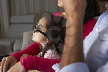 Family Watching TV Wearing 3D Glasses And Eating Popcorn