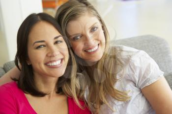 Portrait Of Two Smiling Female Friends On Sofa
