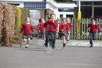 Elementary School Pupils Running In Playground