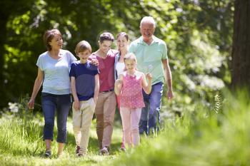 Multi Generation Family Walking Through Summer Countryside