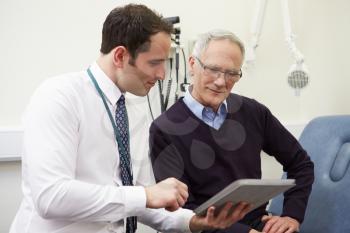 Consultant Showing Patient Test Results On Digital Tablet