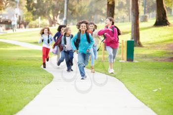 Group Of Children Running Along Path Towards Camera In Park