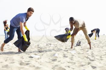 Group Of Volunteers Tidying Up Rubbish On Beach