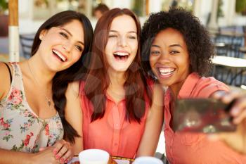 Three Female Friends Taking Selfie In Caf