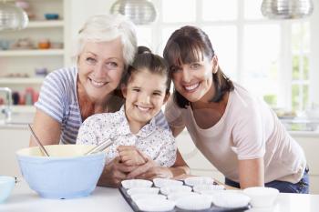 Grandmother, Granddaughter And Mother Baking Cake In Kitchen