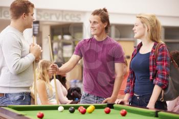 College Students Relaxing And Playing Pool Together