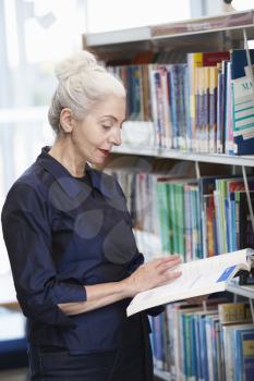 Female Mature Student Studying In Library