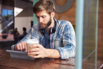 Businessman Working On Digital Tablet In Coffee Shop