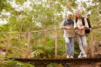 Grandmother and granddaughter on a bridge in a forest