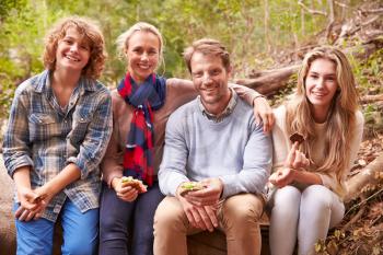 Parents and teenage kids eating outdoors in a forest, portrait