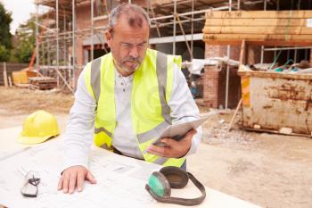 Construction Worker Using Digital Tablet On Building Site