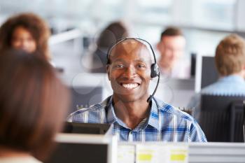 African American man working in call centre, looks to camera
