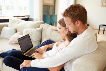 Couple Relaxing Using Laptop Computer For Internet Banking