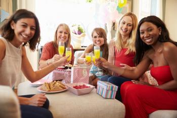 Friends Making A Toast With Orange Juice At Baby Shower